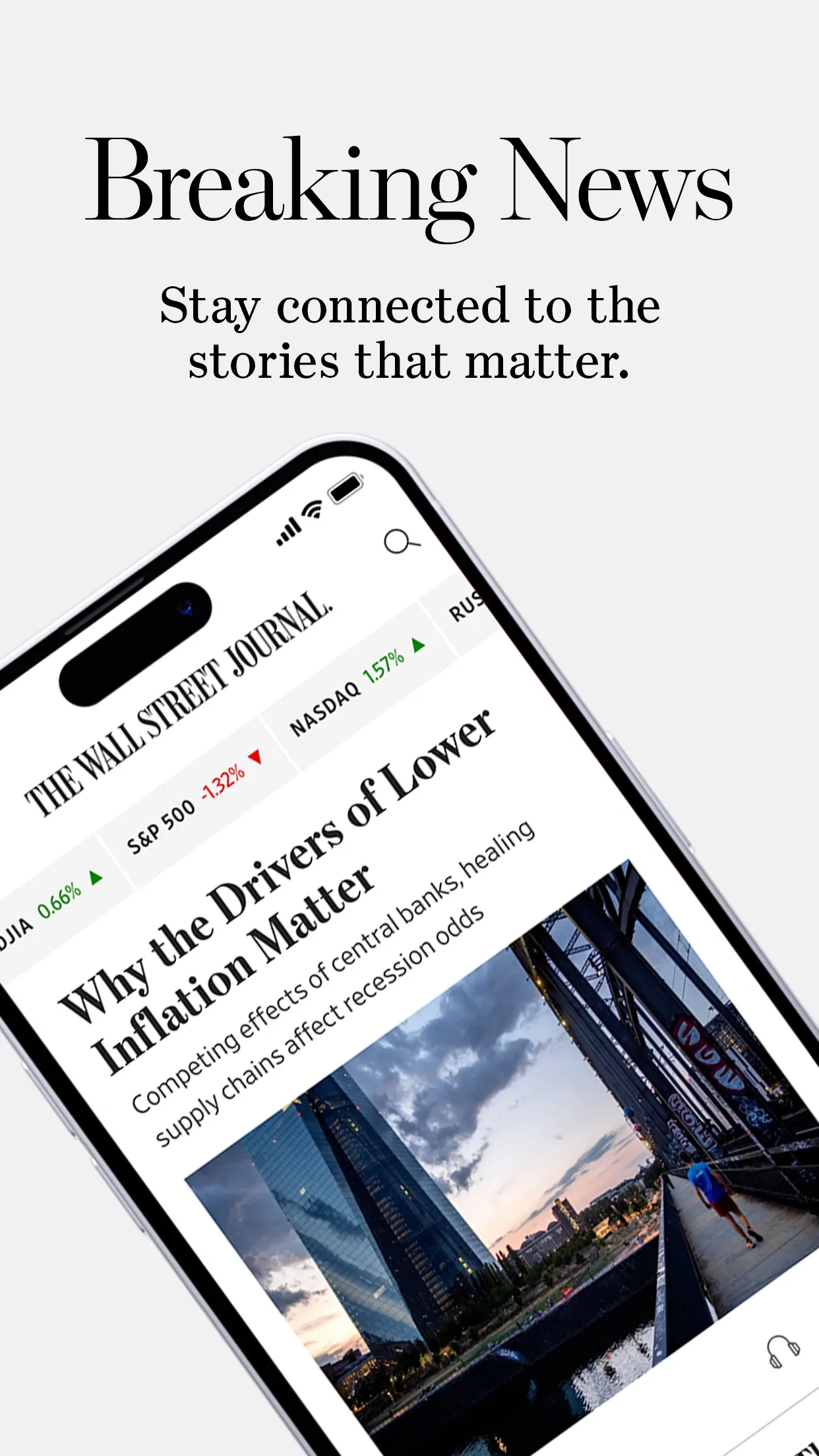 WSJ home feed on a tilted phone with a market strip and the story 'Why the Drivers of Lower Inflation Matter', caption 'Breaking News'